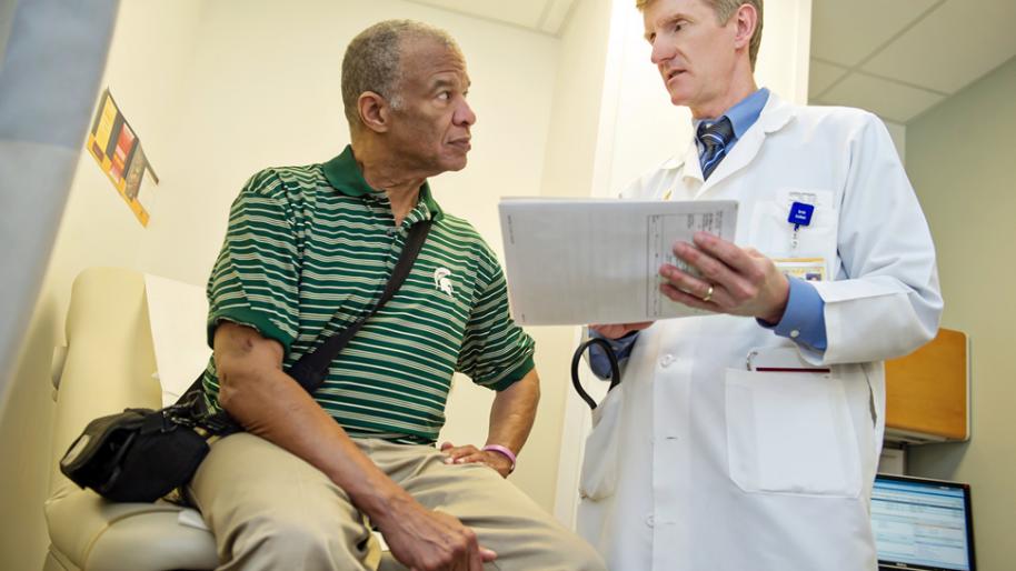 Seated LVAD patient Jerome Wilson and Dr. Todd Koelling discuss heart failure treatment