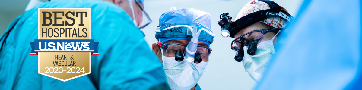 Surgeons wearing masks and loupes, looking down in focused concentration, and Best Hospitals badge showing national ranking for Cardiology & Heart Surgery, 2022-23
